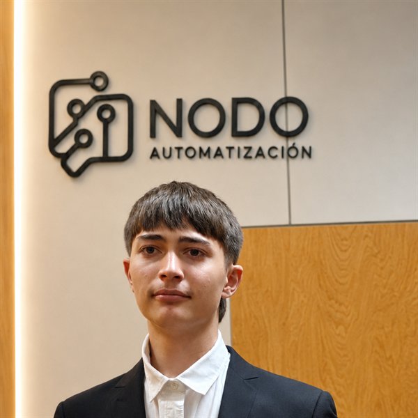 Manuel, fundador de NODO, delante del logo de la marca
